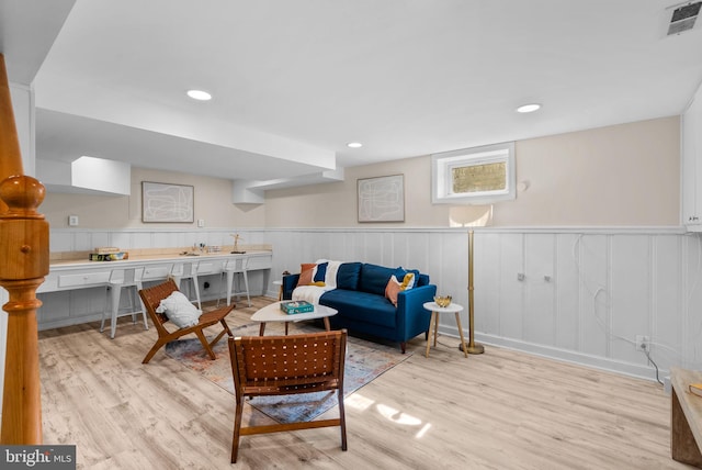 living room with recessed lighting, visible vents, a wainscoted wall, and wood finished floors