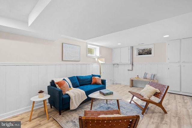 living area featuring recessed lighting, light wood-type flooring, and a wainscoted wall