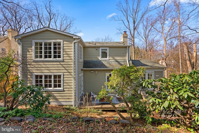 back of house with a deck and a chimney