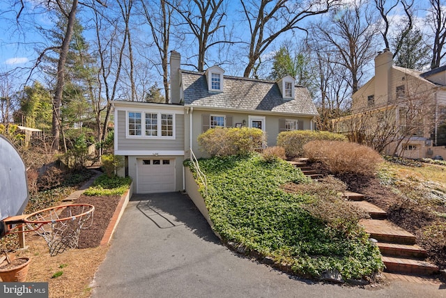 view of front facade featuring a garage, a high end roof, driveway, and a chimney