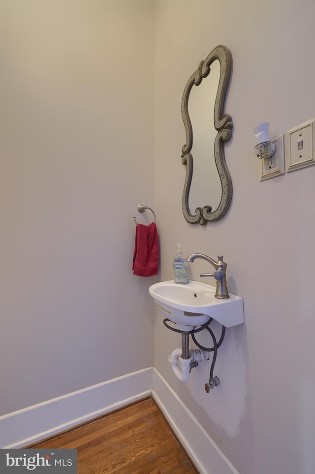 bathroom featuring a sink, baseboards, and wood finished floors