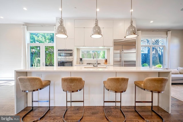 kitchen featuring dark wood-type flooring, appliances with stainless steel finishes, white cabinets, modern cabinets, and a sink