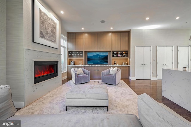 living area featuring recessed lighting, a fireplace, and wood finished floors