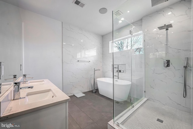 bathroom featuring a marble finish shower, visible vents, a soaking tub, and a sink