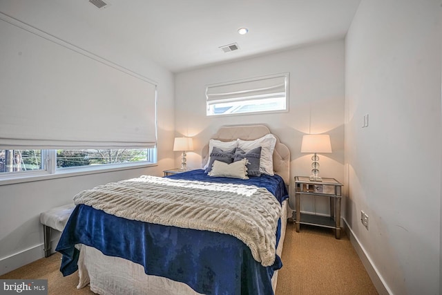 bedroom with carpet flooring, multiple windows, baseboards, and visible vents