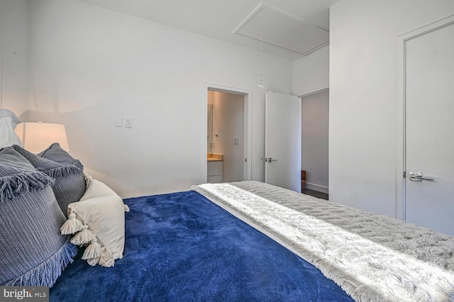 bedroom featuring connected bathroom and attic access