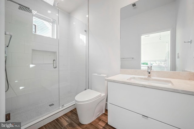 full bath with visible vents, a shower stall, toilet, wood finished floors, and vanity