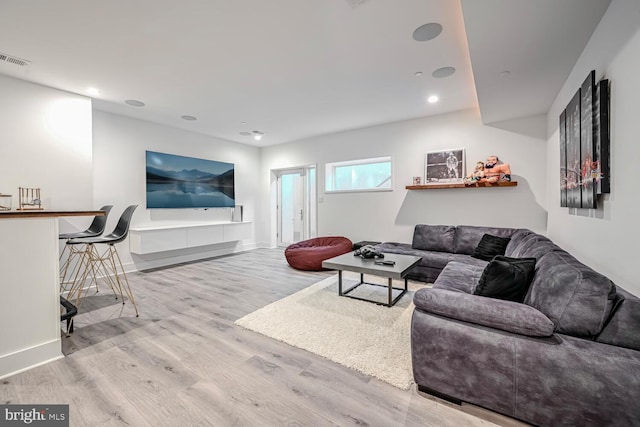 living room with recessed lighting, wood finished floors, visible vents, and baseboards