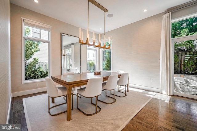 dining space with hardwood / wood-style floors, baseboards, visible vents, and a wealth of natural light