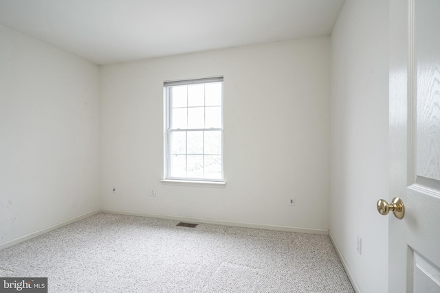 unfurnished room with visible vents, carpet floors, and baseboards