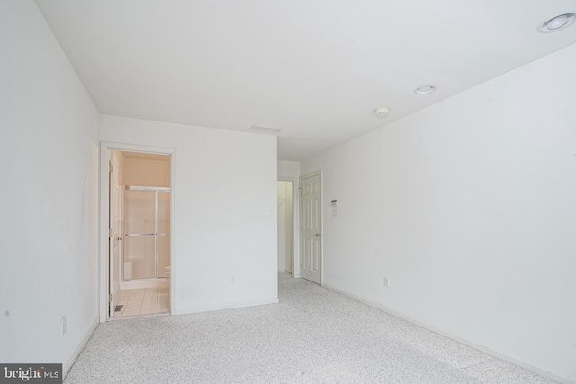 unfurnished bedroom with light carpet, ensuite bath, and baseboards