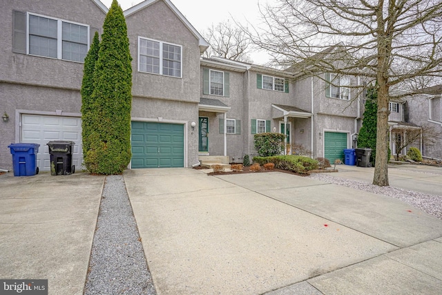 view of front of property with stucco siding, concrete driveway, and an attached garage