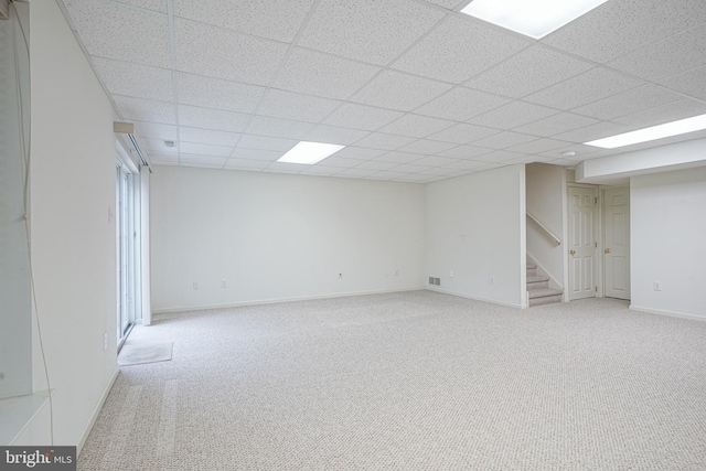 interior space featuring a drop ceiling, stairway, carpet floors, and baseboards