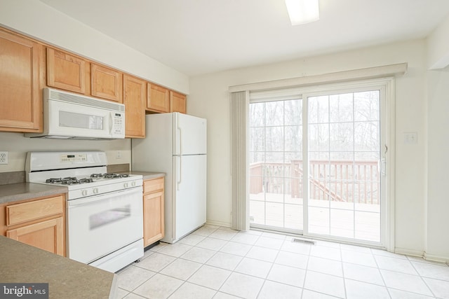 kitchen featuring light tile patterned floors, visible vents, and white appliances