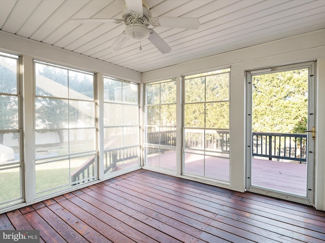 unfurnished sunroom featuring a ceiling fan and a healthy amount of sunlight