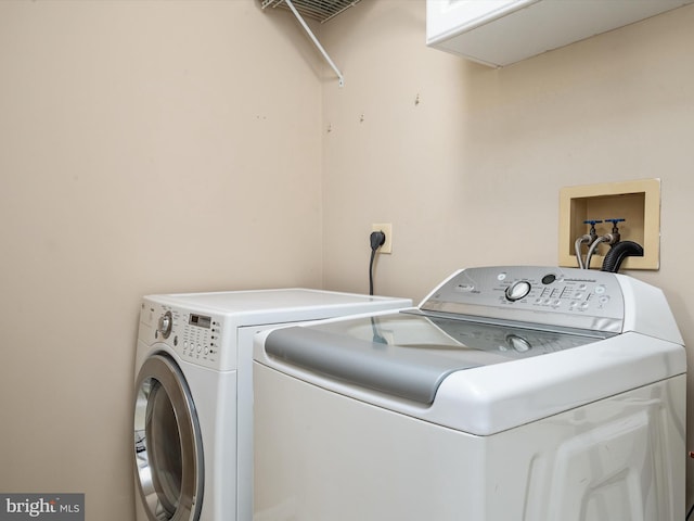 laundry room with independent washer and dryer and cabinet space