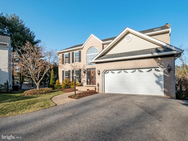 view of front of home featuring a garage, aphalt driveway, roof with shingles, a front lawn, and brick siding