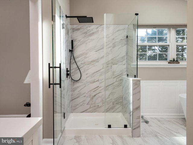 bathroom featuring marble finish floor, a soaking tub, and a marble finish shower