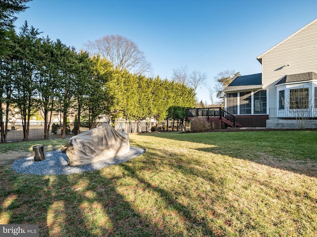 view of yard featuring fence and a sunroom