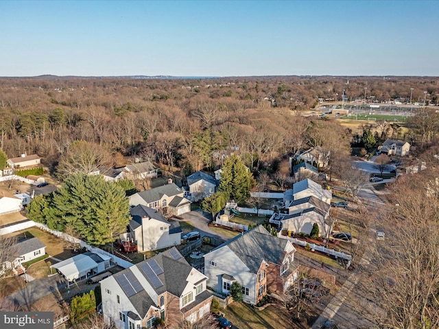 drone / aerial view featuring a residential view and a view of trees