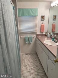 full bath featuring vanity, a shower with curtain, and tile patterned flooring