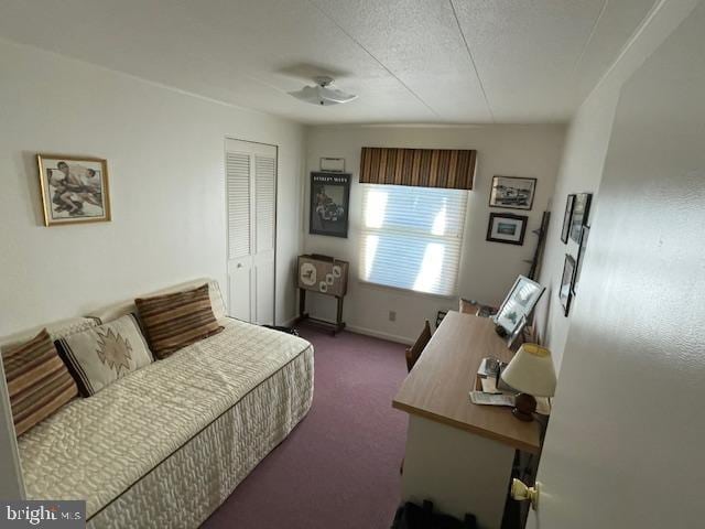 bedroom featuring baseboards, a closet, dark carpet, and a textured ceiling