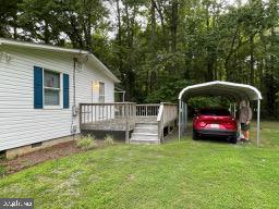 view of yard featuring a detached carport and a deck