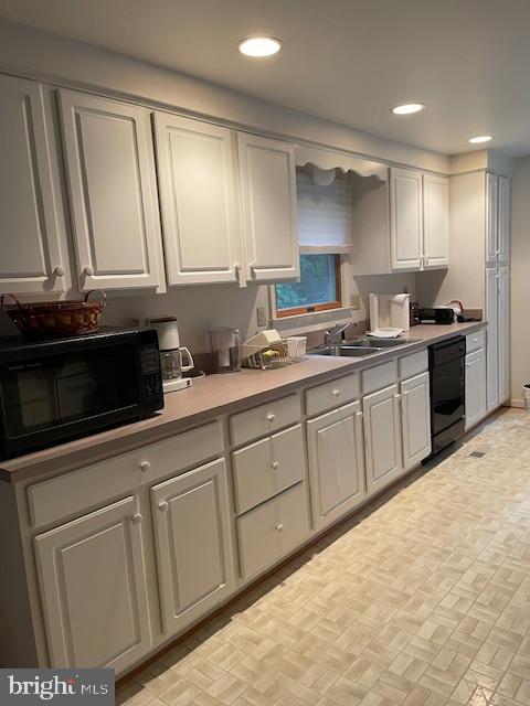 kitchen with black appliances, recessed lighting, light countertops, and a sink