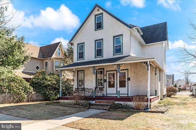 view of front of house with a porch, a shingled roof, fence, and stucco siding