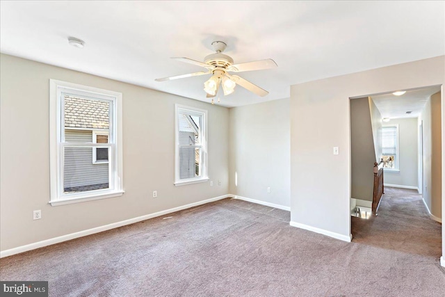 unfurnished room featuring carpet floors, baseboards, and a ceiling fan