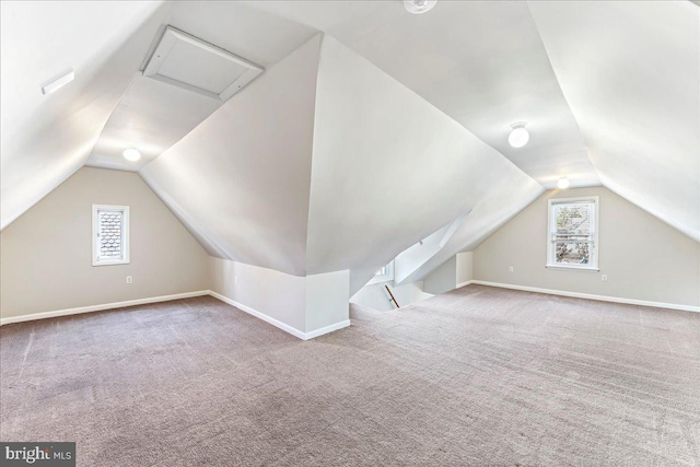 additional living space featuring baseboards, vaulted ceiling, and carpet flooring