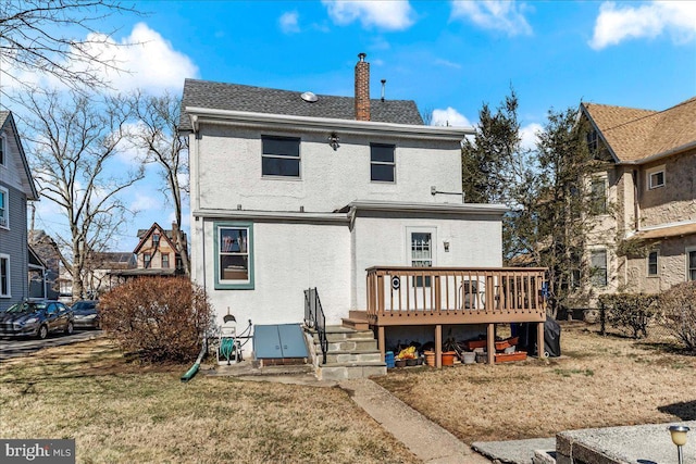 rear view of house with a deck, roof with shingles, a chimney, and stucco siding