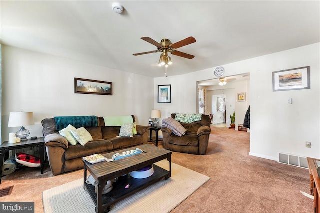 living area with a ceiling fan, visible vents, light carpet, and baseboards