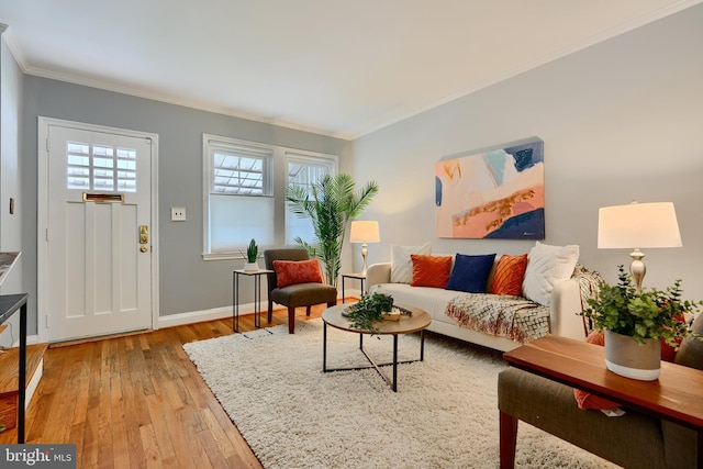 living area with light wood-style floors, ornamental molding, plenty of natural light, and baseboards
