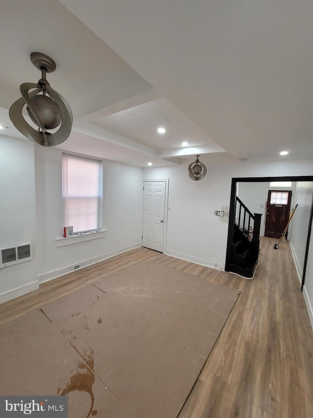 basement with stairs, wood finished floors, visible vents, and baseboards