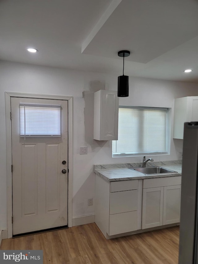 kitchen with a wealth of natural light, light countertops, a sink, and freestanding refrigerator