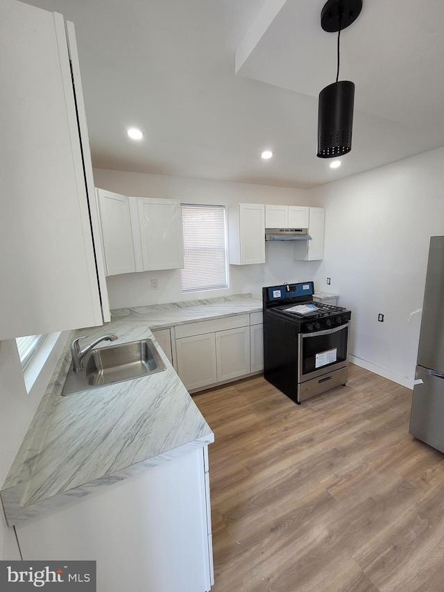 kitchen featuring stainless steel appliances, recessed lighting, light wood-style floors, white cabinets, and a sink