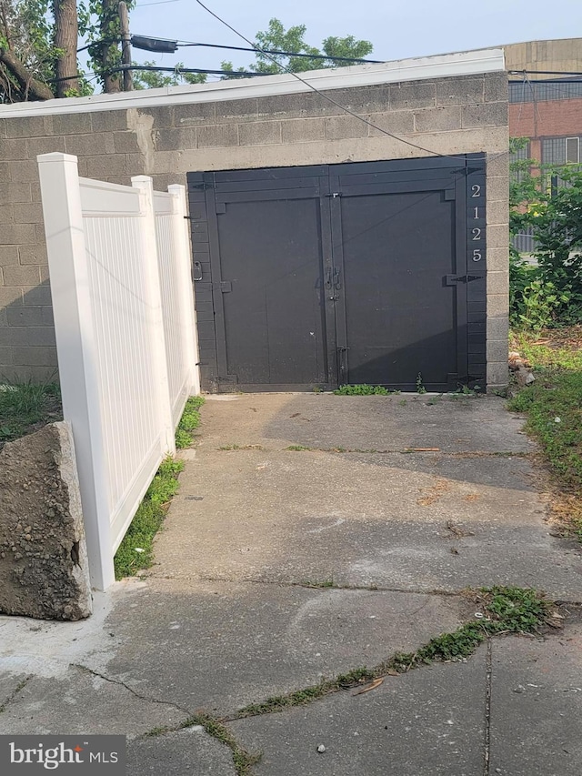 view of gate featuring an outbuilding and fence