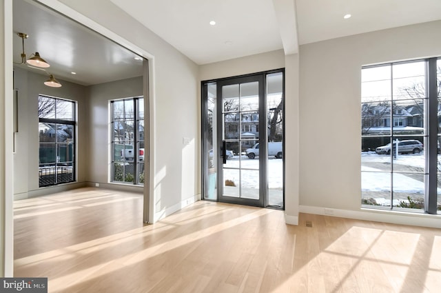 doorway to outside with baseboards, wood finished floors, and recessed lighting