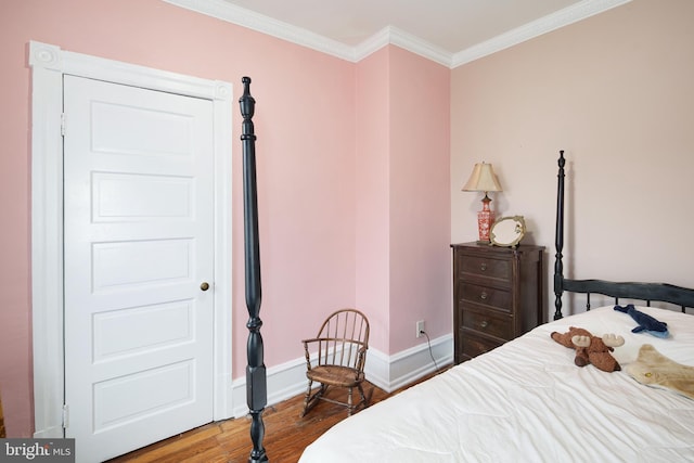 bedroom featuring baseboards, crown molding, and wood finished floors