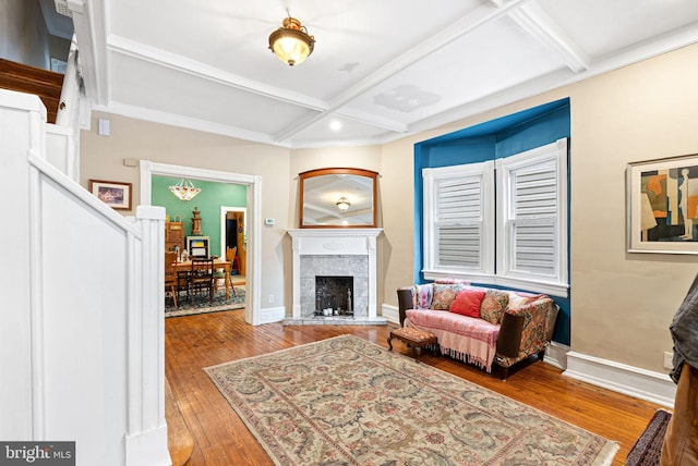 living room with a premium fireplace, beamed ceiling, baseboards, hardwood / wood-style floors, and coffered ceiling