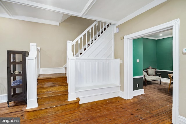 stairway with hardwood / wood-style floors, ornamental molding, and baseboards