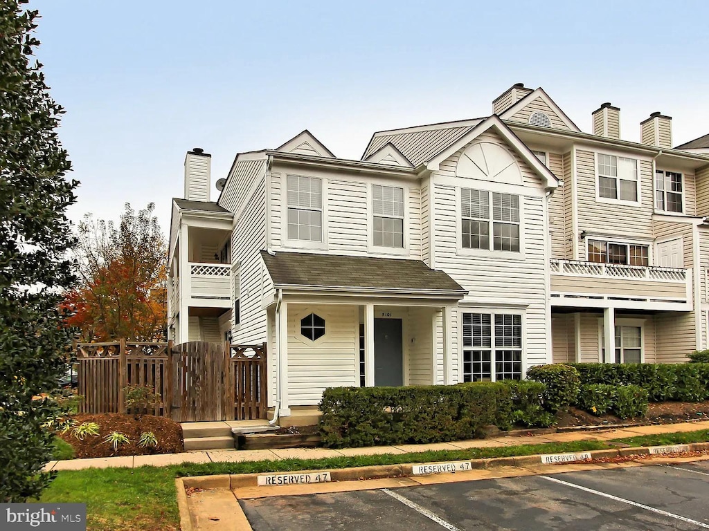 townhome / multi-family property featuring uncovered parking and a chimney