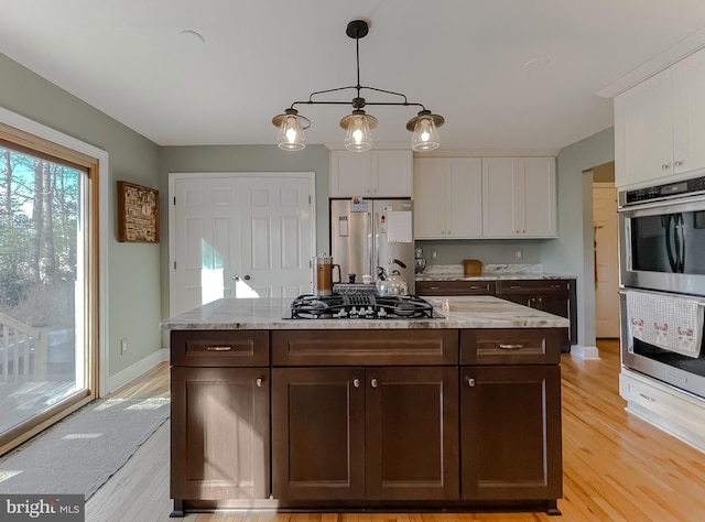 kitchen with dark brown cabinetry, pendant lighting, appliances with stainless steel finishes, and white cabinetry