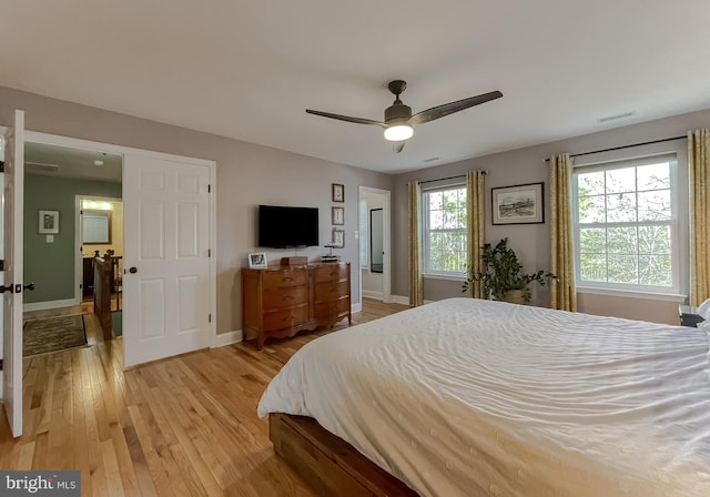 bedroom with light wood finished floors, visible vents, a ceiling fan, and baseboards