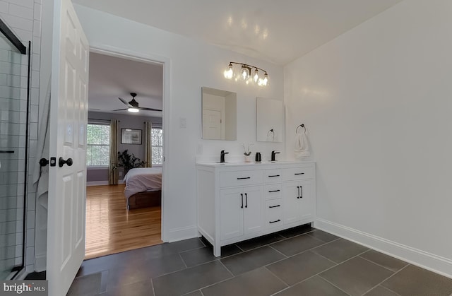 ensuite bathroom featuring tile patterned floors, connected bathroom, baseboards, and double vanity