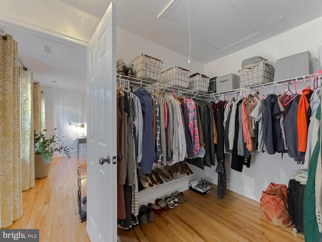 spacious closet featuring visible vents, attic access, and wood finished floors