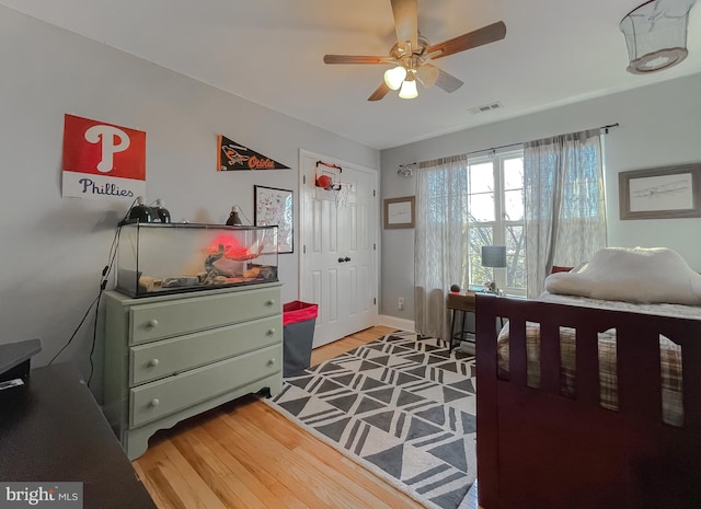 bedroom with light wood-type flooring, baseboards, visible vents, and ceiling fan