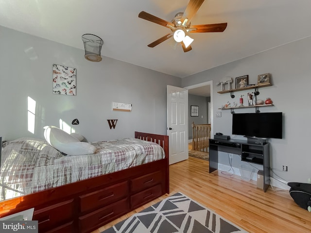 bedroom featuring light wood-style flooring, baseboards, and ceiling fan