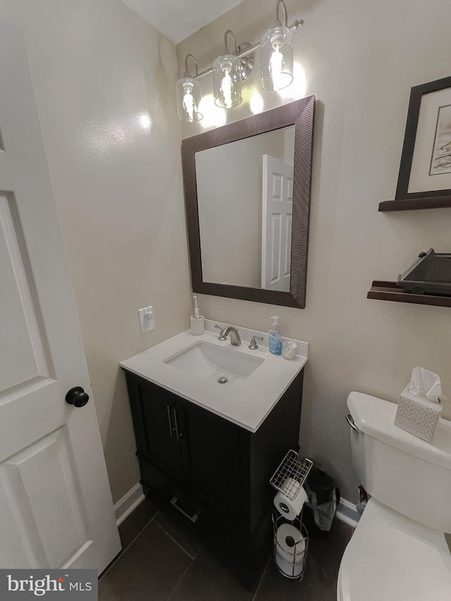 bathroom with baseboards, toilet, and vanity